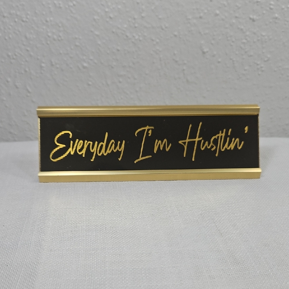 desk sign/plaque with 'Everyday I'm Hustlin'' in gold letters on gold background